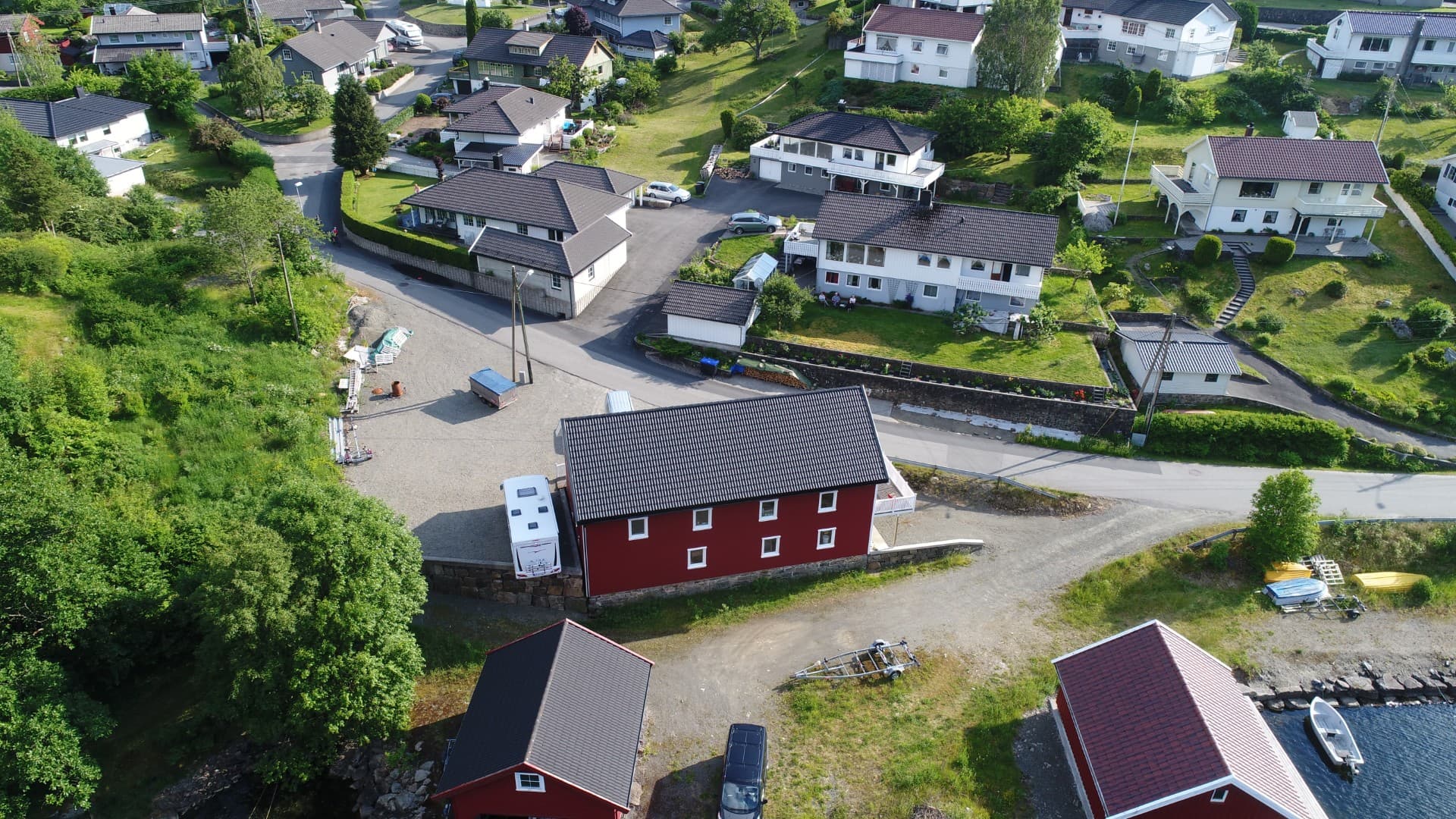 Villmo’s Selskapslokale sett fra vannet med uteområde og egen parkeringsplass